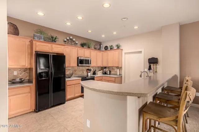 a kitchen with stainless steel appliances granite countertop a refrigerator and stove top oven
