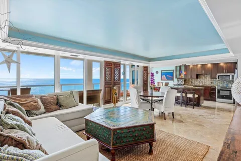 a kitchen with stainless steel appliances granite countertop a stove top oven a refrigerator a sink and chairs