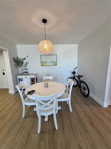 a dining room with furniture a chandelier and wooden floor