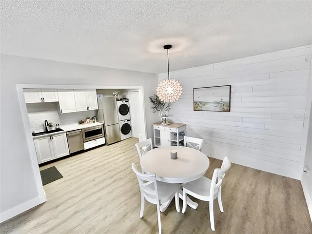 a view of a dining room with furniture a chandelier and wooden floor