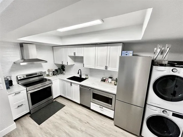 a kitchen with stainless steel appliances a stove a sink and a refrigerator