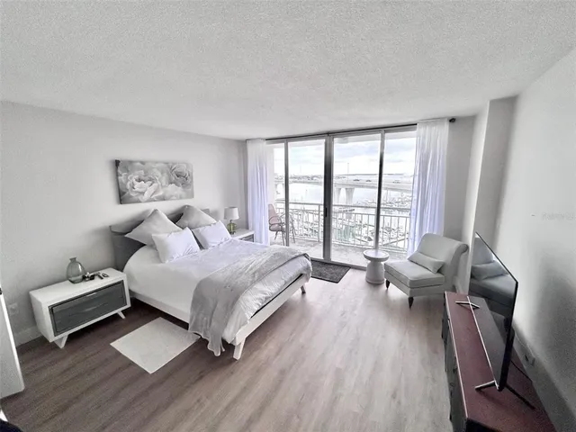 a spacious bedroom with a bed and wooden floor