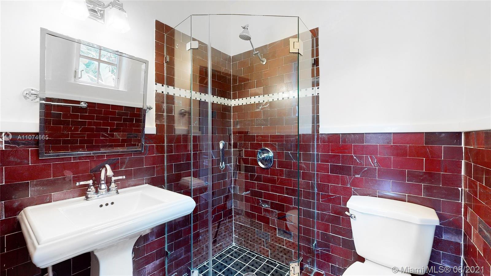 2032 Alton Road Miami Beach, FL 33140 - Photo 26 of 35 a bathroom with a toilet a sink and mirror