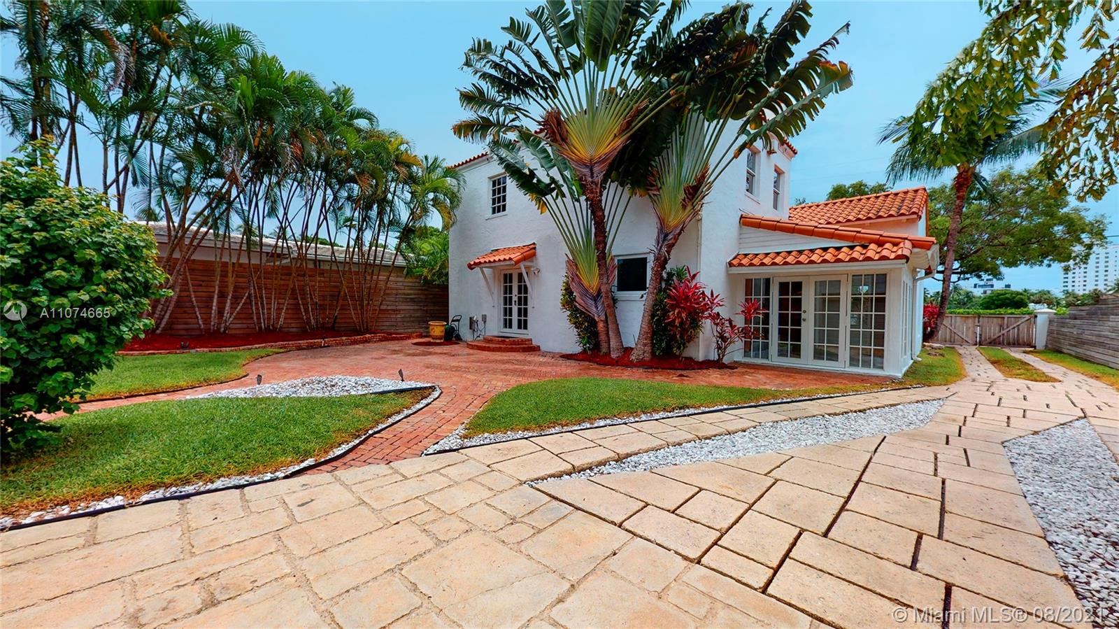 2032 Alton Road Miami Beach, FL 33140 - Photo 28 of 35 a view of a backyard with a bench and a lawn chair under palm trees
