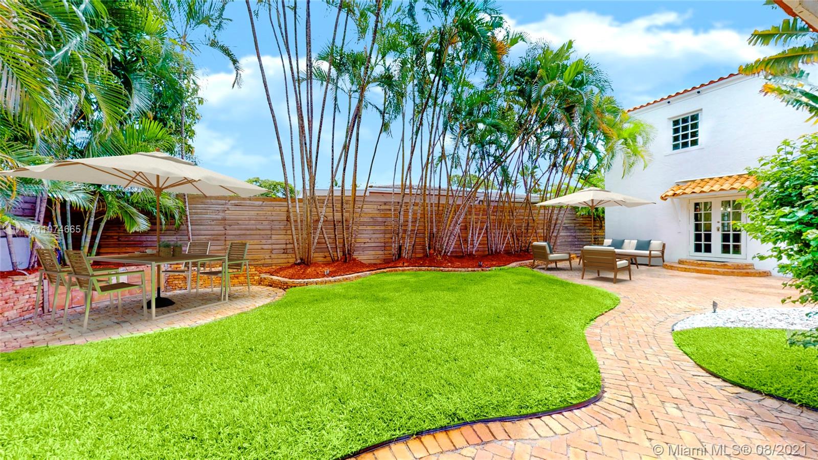 2032 Alton Road Miami Beach, FL 33140 - Photo 29 of 35 a view of a backyard with a table and chairs under an umbrella