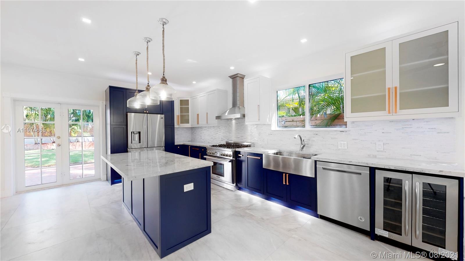 2032 Alton Road Miami Beach, FL 33140 - Photo 6 of 35 a kitchen with stainless steel appliances granite countertop wooden cabinets sink and wooden floor