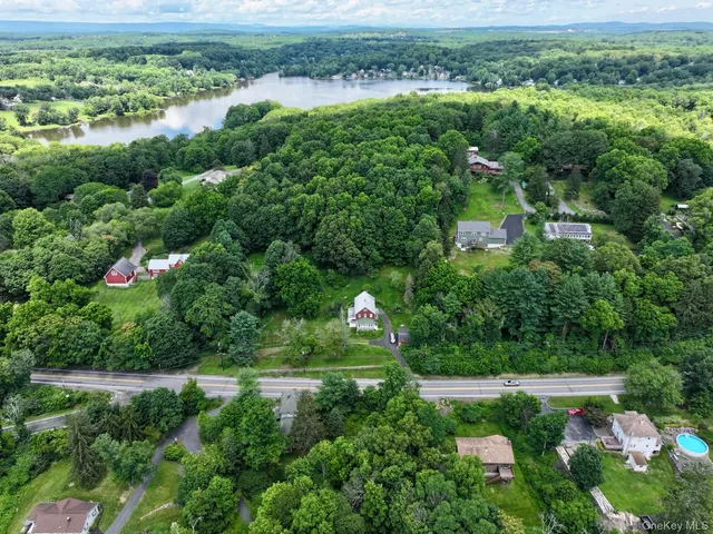 an aerial view of a houses with a yard and lake view