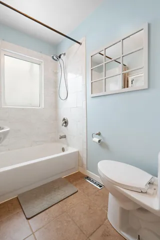 a bathroom with a granite countertop sink a toilet and shower