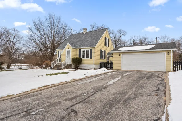 a view of a white house with a snow on the road