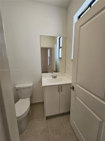 a bathroom with a sink mirror vanity and toilet