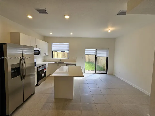 a large kitchen with a large counter top stainless steel appliances and cabinets