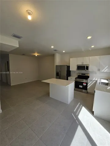 a large white kitchen with a large window