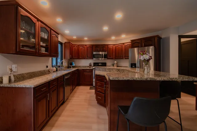 a kitchen with kitchen island granite countertop wooden cabinets a sink and a center island