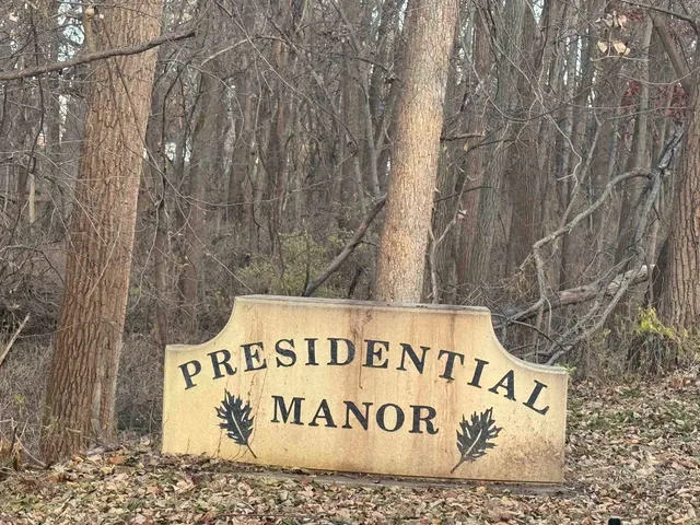 a living room with furniture a fireplace and a large mirror with wooden floor