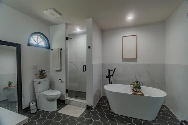 a bed sitting in a bedroom next to a window