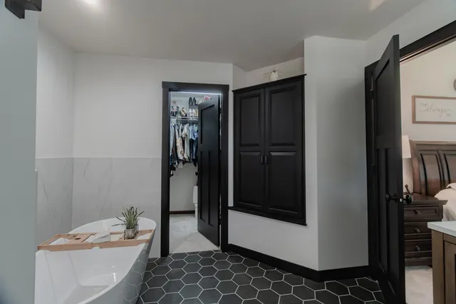 a bedroom with a bed and a chandelier fan