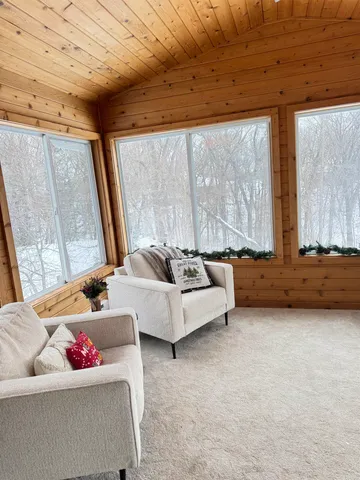 a living room with furniture floor to ceiling window and a potted plant
