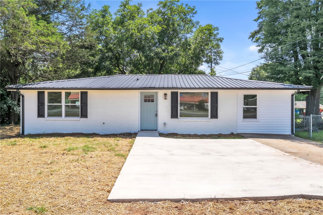 A newly updated exterior with crisp white siding and painted brick and a durable metal roof offers inviting curb appeal.