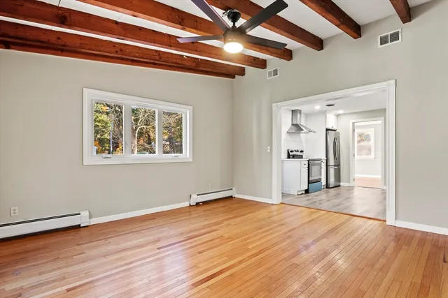 a view of empty room with wooden floor