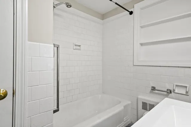 a bathroom with a bathtub and shower