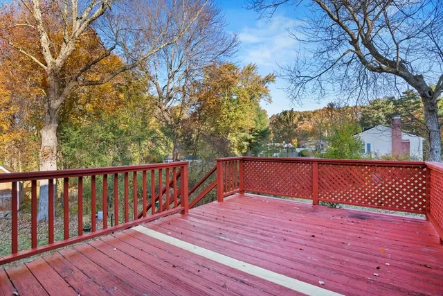a balcony with wooden floor and trees