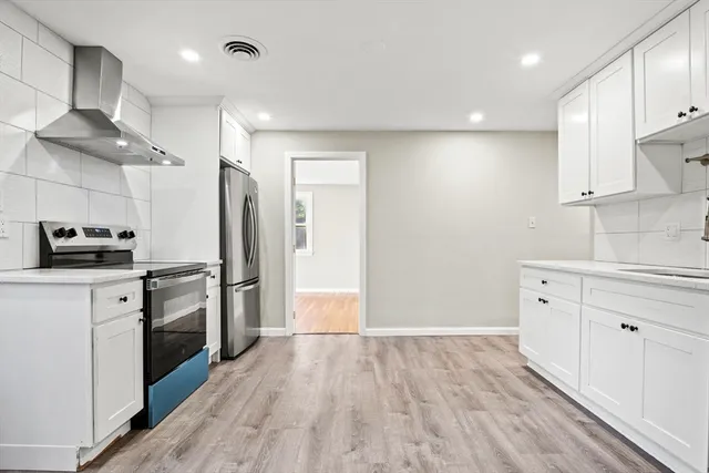 a kitchen with a refrigerator and a stove top oven