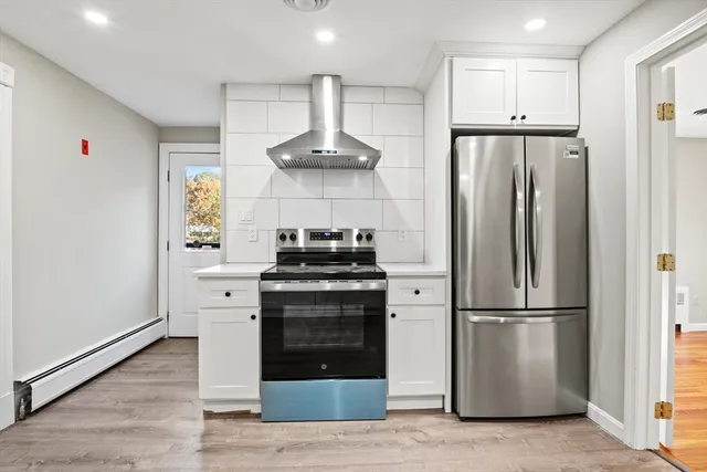 a kitchen with stainless steel appliances granite countertop a refrigerator and a stove