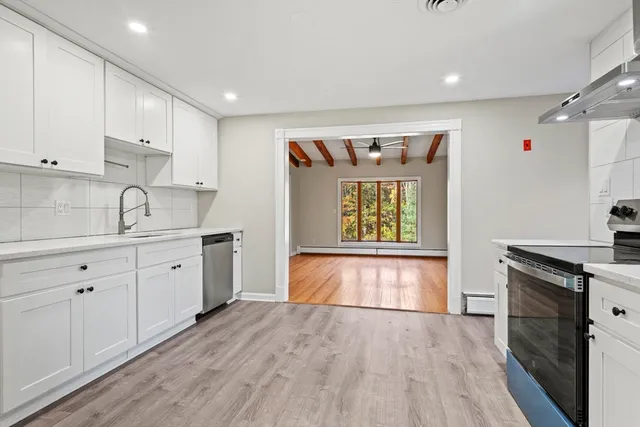 a kitchen with granite countertop a stove a sink and a refrigerator