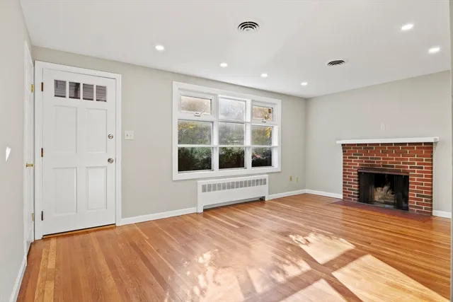 a view of an empty room with window and fire place
