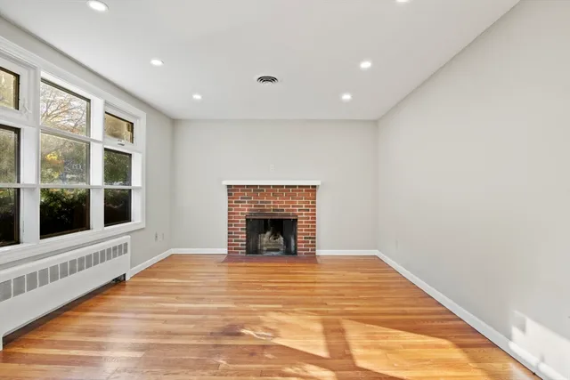 a view of an empty room with a fireplace and a window