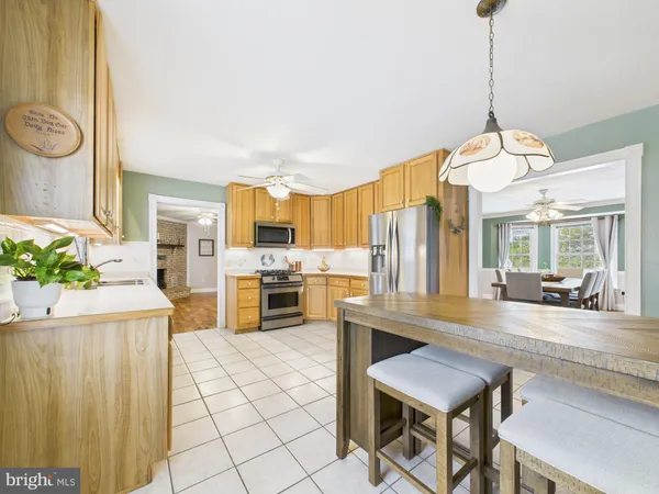 a view of an empty room with window and a kitchen