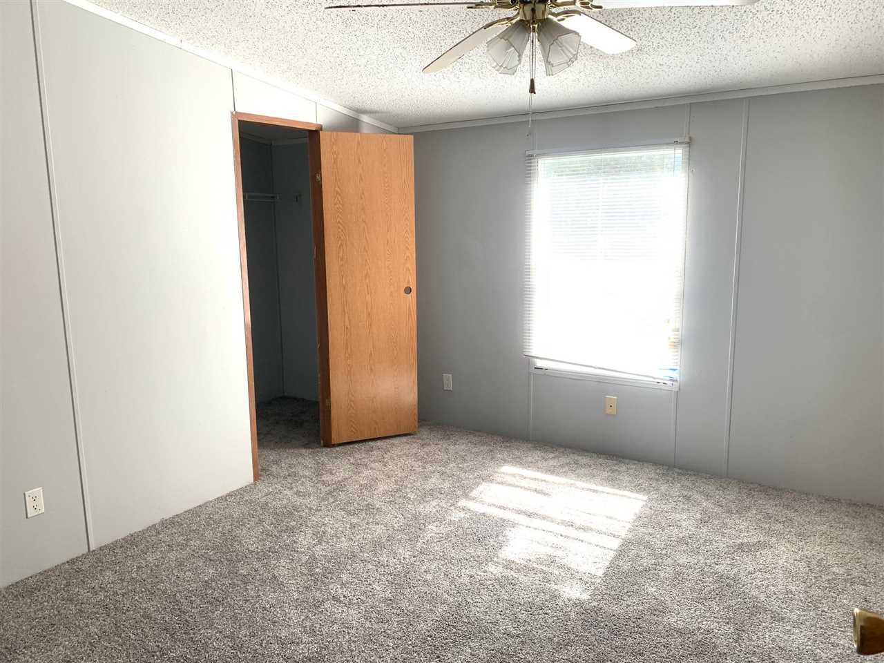 2176 Puron Road Adamsville, TN 38310 - Photo 10 of 24 an empty room with a window and chandelier fan