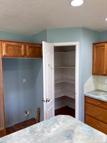 587 West 2400 South Perry, UT 84302 - Photo 15 of 46 Kitchen featuring a corner pantry with built-in shelving, recessed ceiling lighting, wood cabinetry, and a patterned backsplash