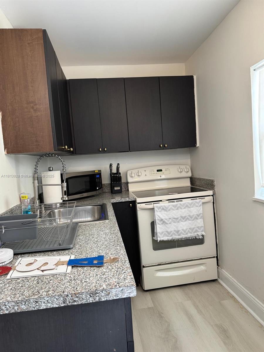 1301 Grouper Drive, Unit B Marathon, FL 33050 - Photo 12 of 39 a kitchen with granite countertop wooden cabinets and a stove top oven