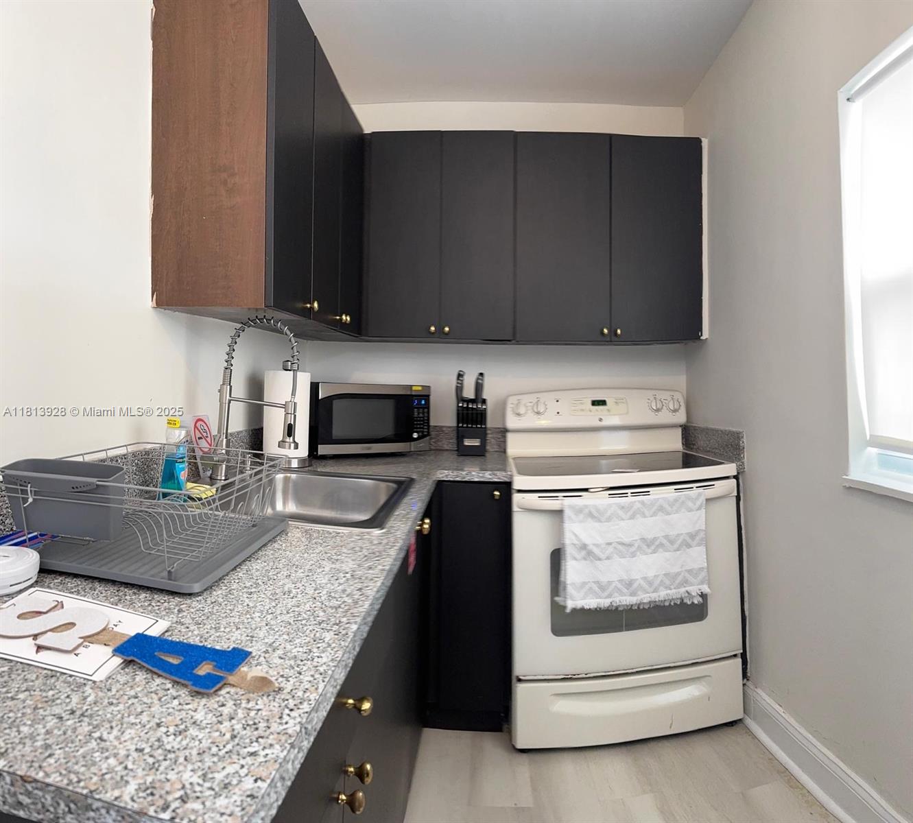 1301 Grouper Drive, Unit B Marathon, FL 33050 - Photo 21 of 39 a kitchen with granite countertop wooden cabinets and black appliances