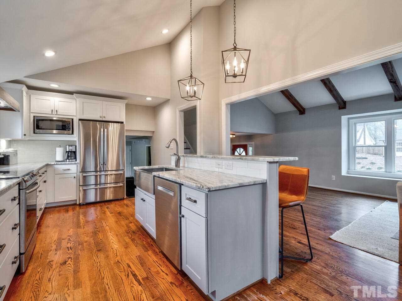 1201 Chardon Court Raleigh, NC 27609 - Photo 13 of 30 a kitchen with stainless steel appliances granite countertop a sink a stove and a wooden floors