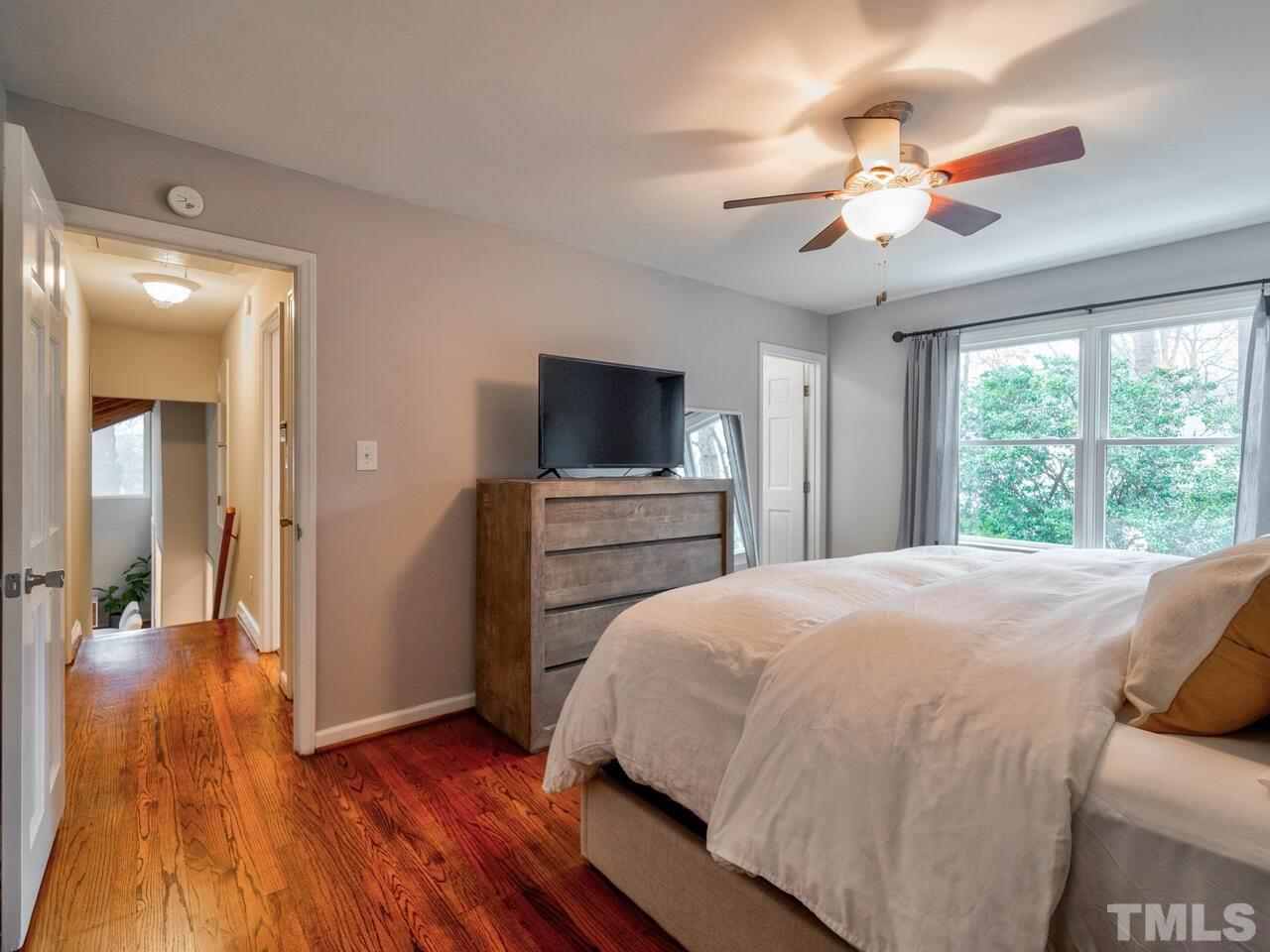 1201 Chardon Court Raleigh, NC 27609 - Photo 18 of 30 a bedroom with a bed and a chandelier