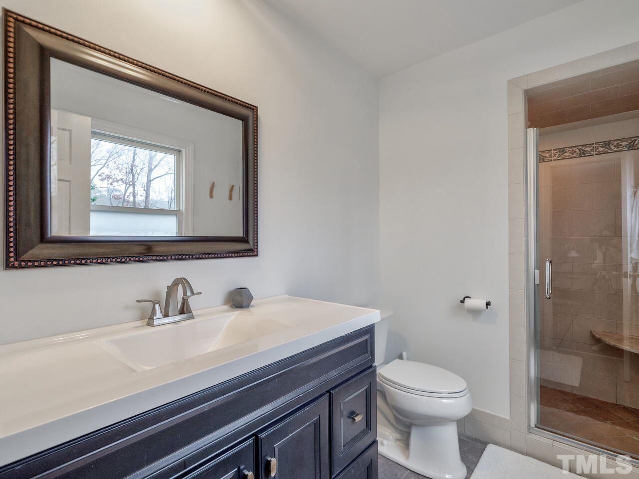 1201 Chardon Court Raleigh, NC 27609 - Photo 19 of 30 a bathroom with a toilet a sink and mirror