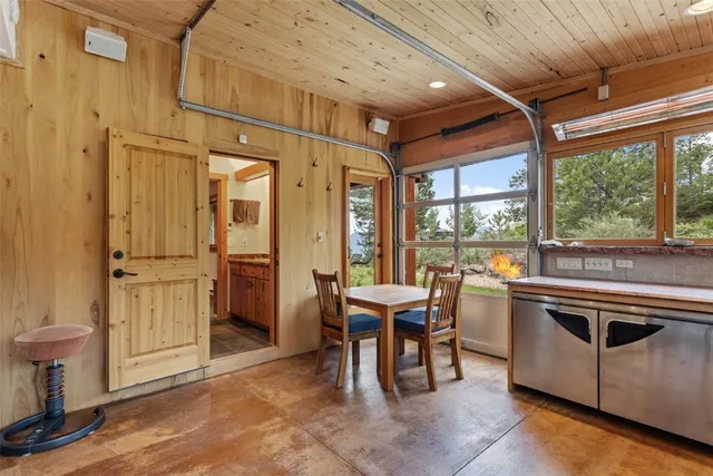 a kitchen with stainless steel appliances kitchen island granite countertop a table chairs and a refrigerator