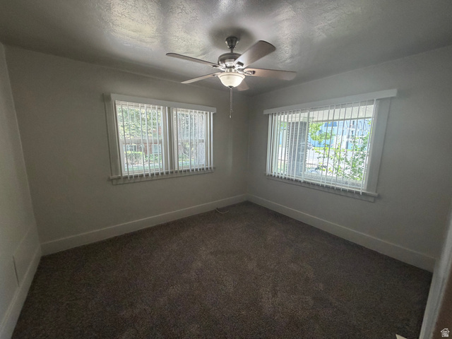 2205 East 3300 South Millcreek, UT 84109 - Photo 18 of 23 Carpeted room featuring a ceiling fan with integrated lighting, two windows with vertical blinds, and white baseboards