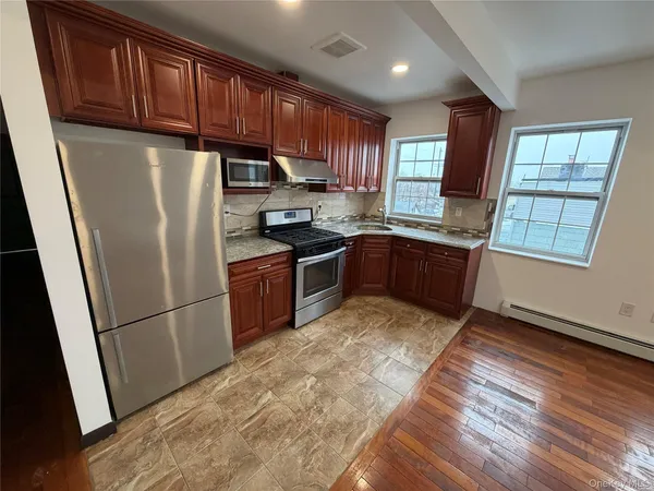 a kitchen with granite countertop stainless steel appliances a refrigerator a sink a stove a microwave and cabinets