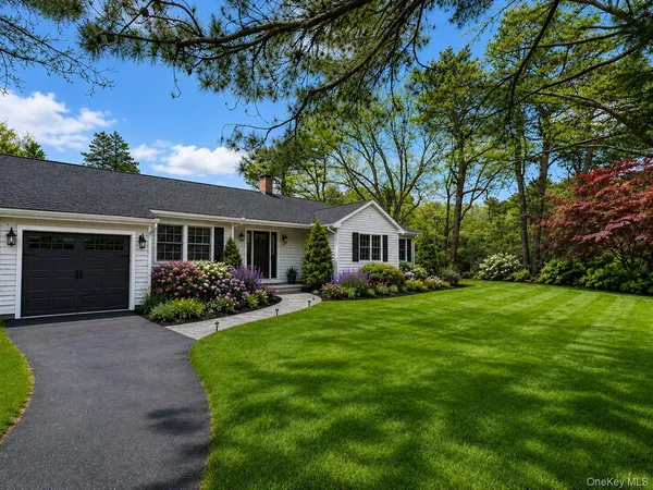 a front view of a house with a garden and yard