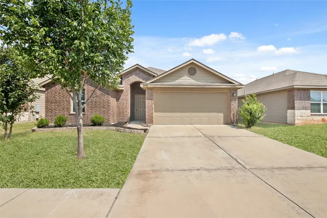 a house with green field in front of it