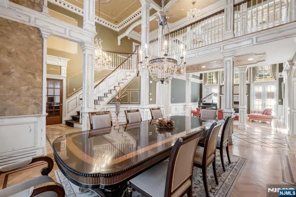 a dining room with furniture a chandelier and wooden floor