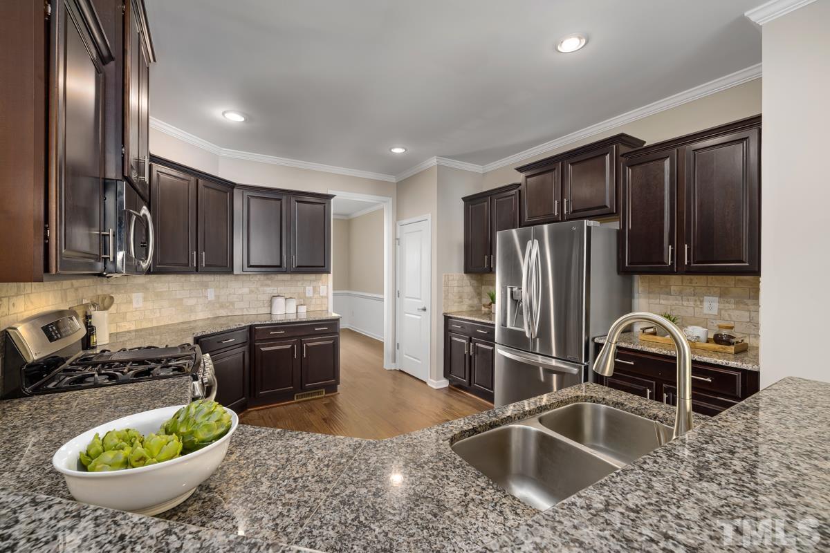 1335 Rodessa Run Raleigh, NC 27607 - Photo 11 of 36 a kitchen with stainless steel appliances a sink a stove a refrigerator and cabinets