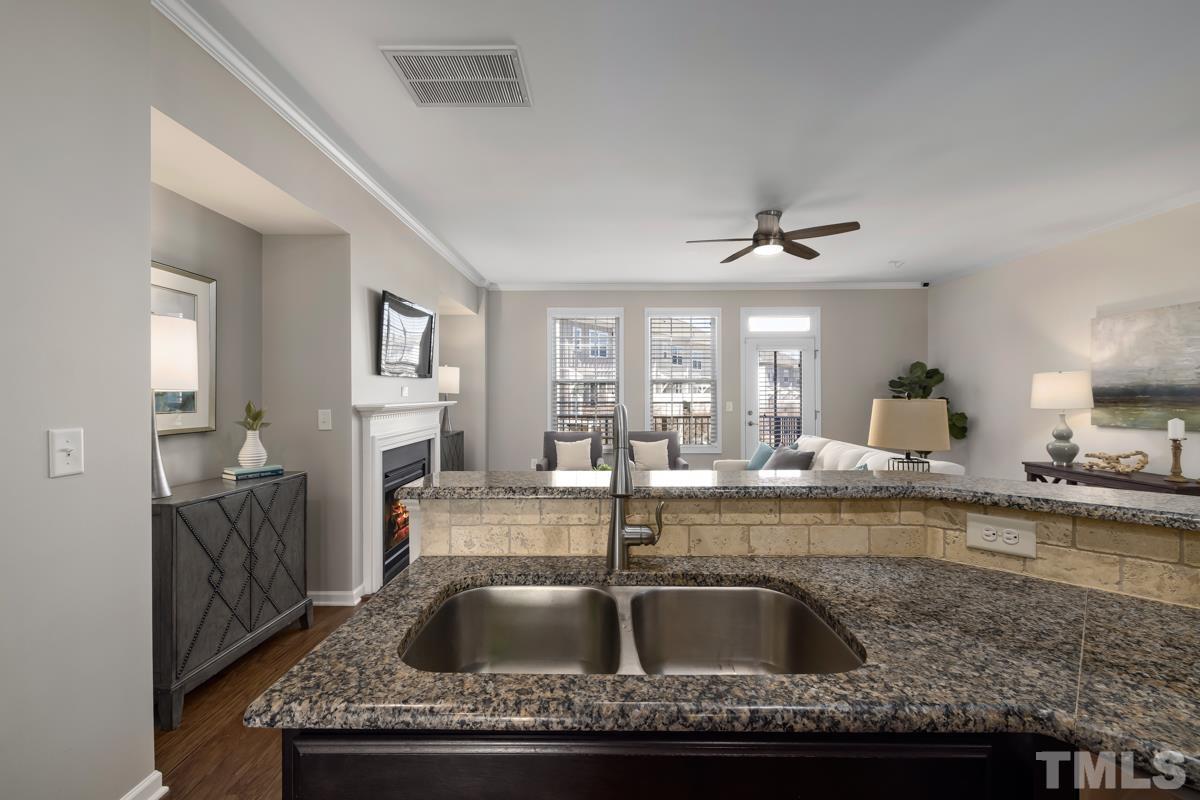 1335 Rodessa Run Raleigh, NC 27607 - Photo 12 of 36 a kitchen with granite countertop a sink a counter top space and living room view