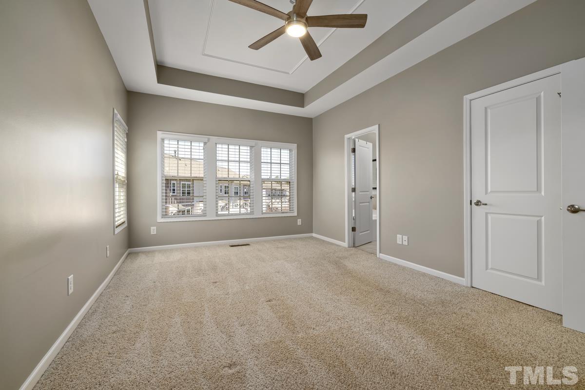 1335 Rodessa Run Raleigh, NC 27607 - Photo 16 of 36 an empty room with chandelier fan and windows