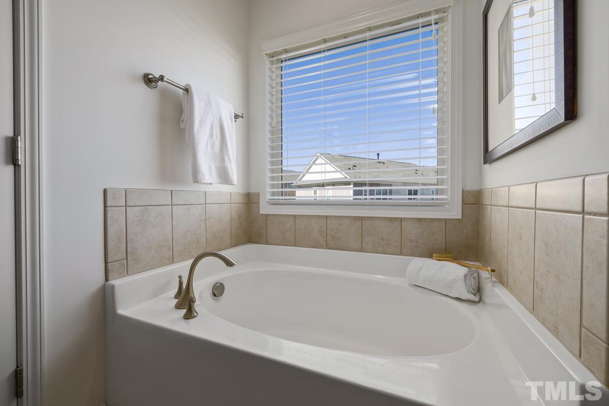 1335 Rodessa Run Raleigh, NC 27607 - Photo 20 of 36 a white bath tub sitting in a bathroom next to a window