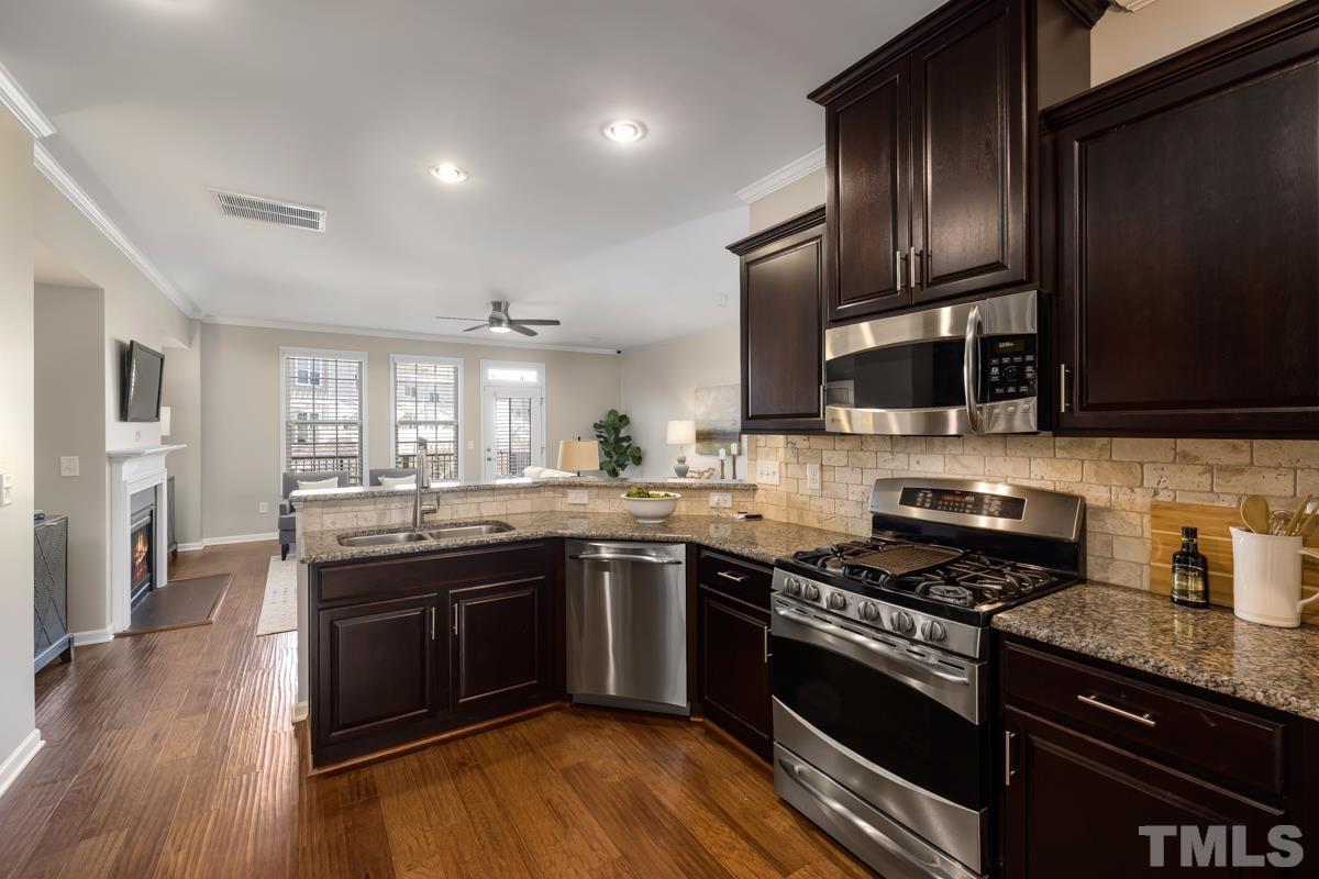 1335 Rodessa Run Raleigh, NC 27607 - Photo 10 of 36 a kitchen with stainless steel appliances granite countertop a stove and a sink