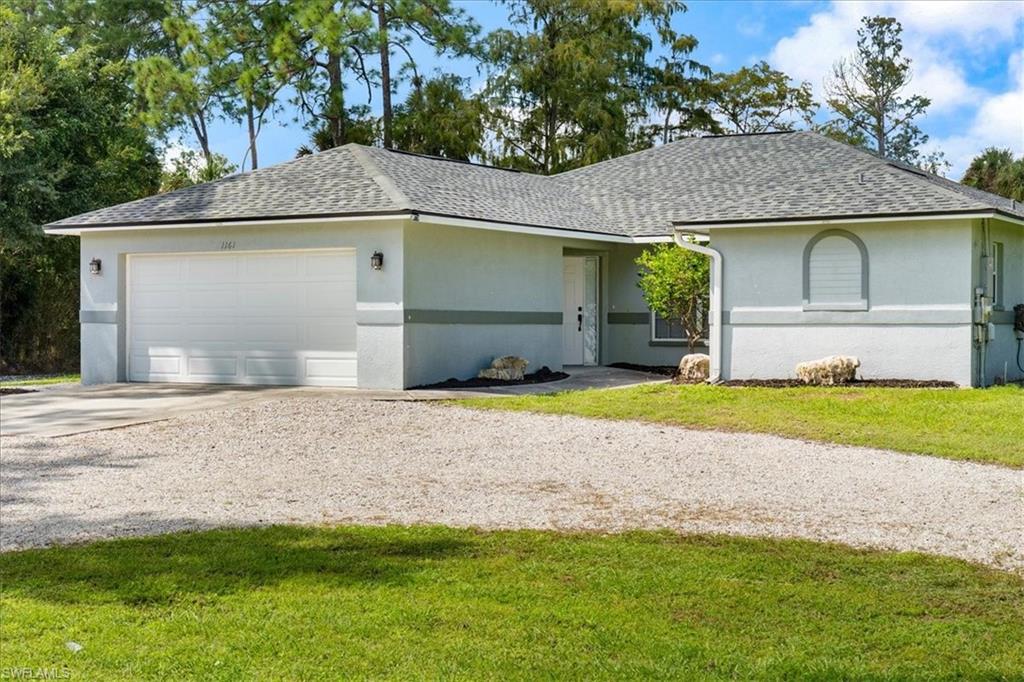 1161 25th Street Southwest Naples, FL 34117 - Photo 2 of 23 a view of a house with a yard and garage